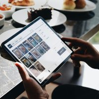 a person holding a tablet at a restaurant table