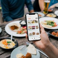 A mobile phone taking a picture of a table of food